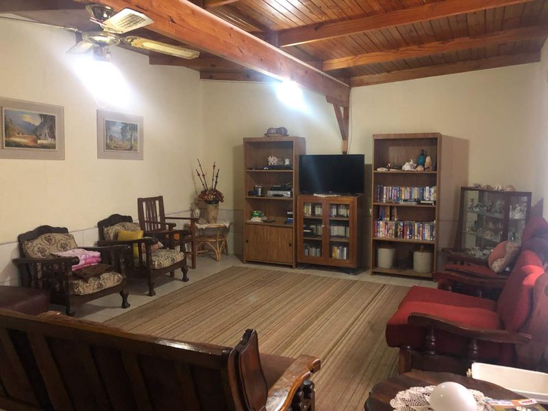 A living room featuring exposed timber ceiling beams and a timber plank ceiling, providing a rustic aesthetic.