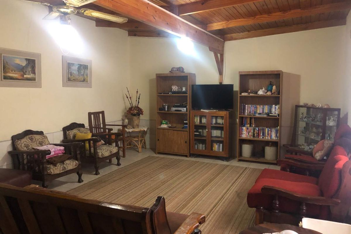 A living room featuring exposed timber ceiling beams and a timber plank ceiling, providing a rustic aesthetic.