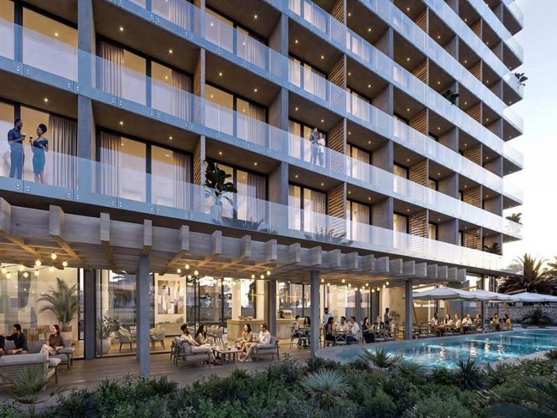 Modern hotel exterior featuring a swimming pool, covered patio area with timber pergola, and multi-level balconies with glass railings.