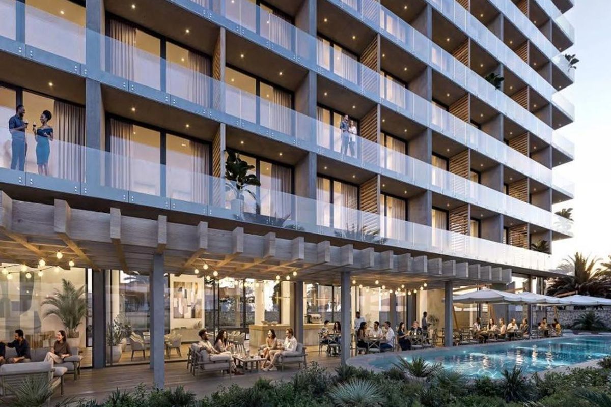 Modern hotel exterior featuring a swimming pool, covered patio area with timber pergola, and multi-level balconies with glass railings.