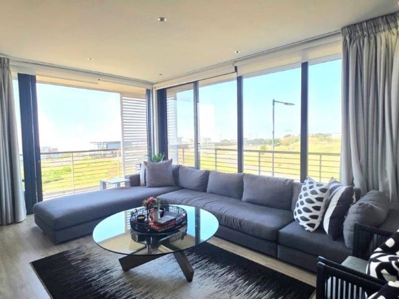 Spacious living room featuring large floor-to-ceiling sliding glass doors that provide abundant natural light and access to an outdoor balcony area.