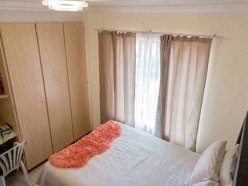 A bedroom featuring built-in cupboards, crown molding, and a ceiling light fixture, providing a functional and well-lit living space.