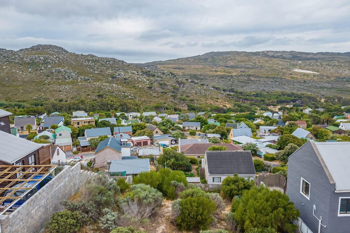 An elevated aerial view of a residential neighborhood nestled against a scenic mountain backdrop.