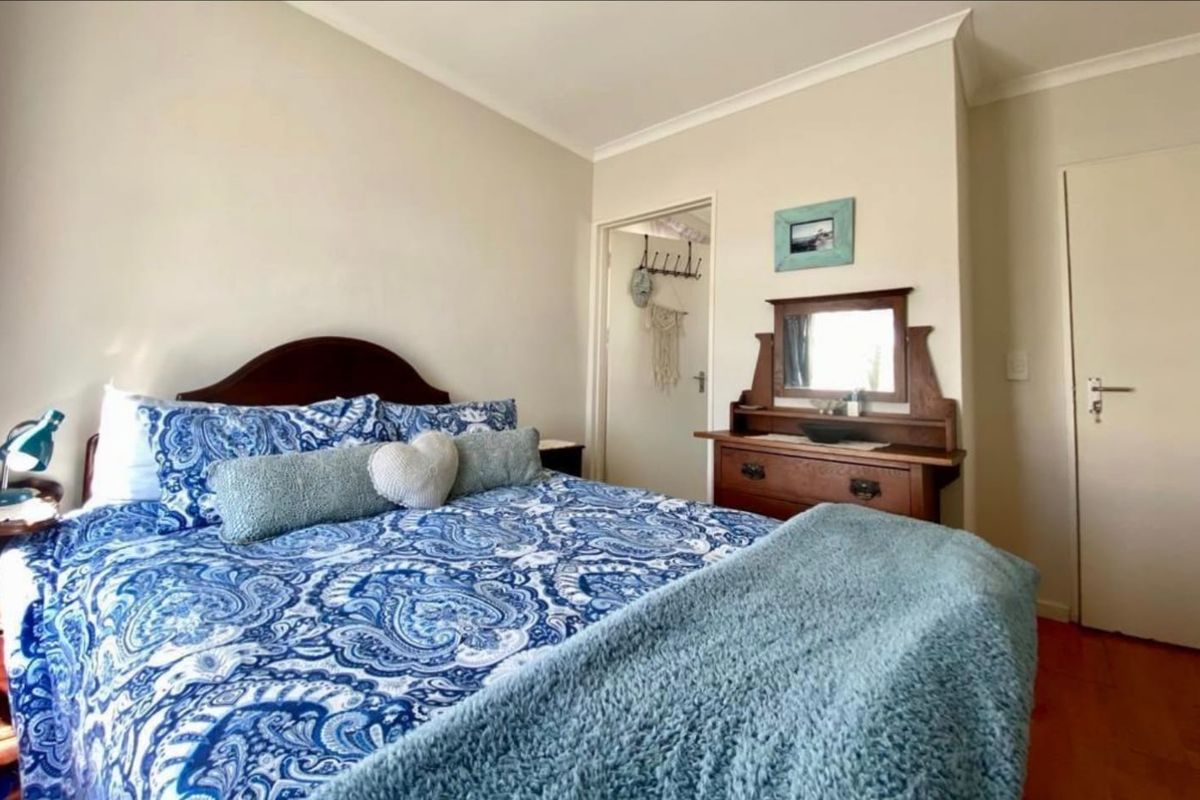 A standard bedroom featuring neutral wall finishes, cove cornicing, and access to an adjoining space via an internal door.