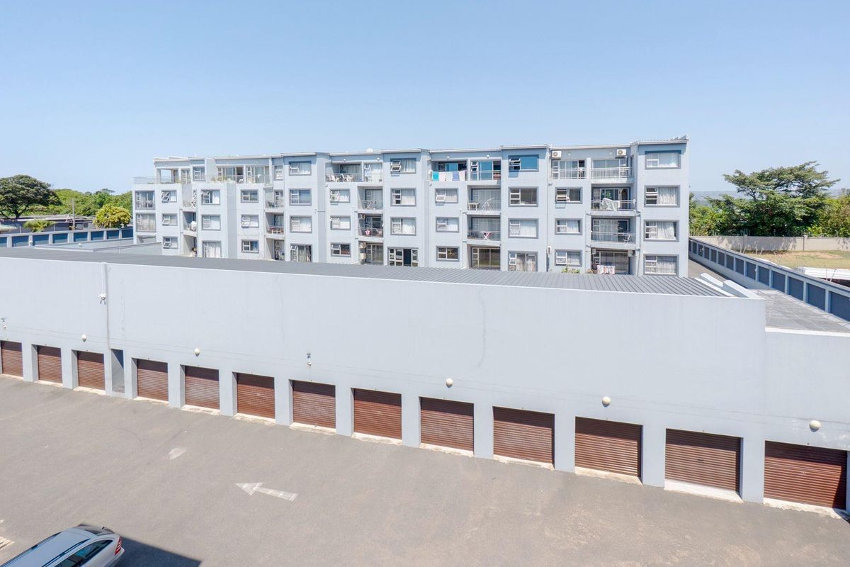 Aerial view of the apartment complex featuring a row of secure lock-up garages and multi-story residential units with private balconies.
