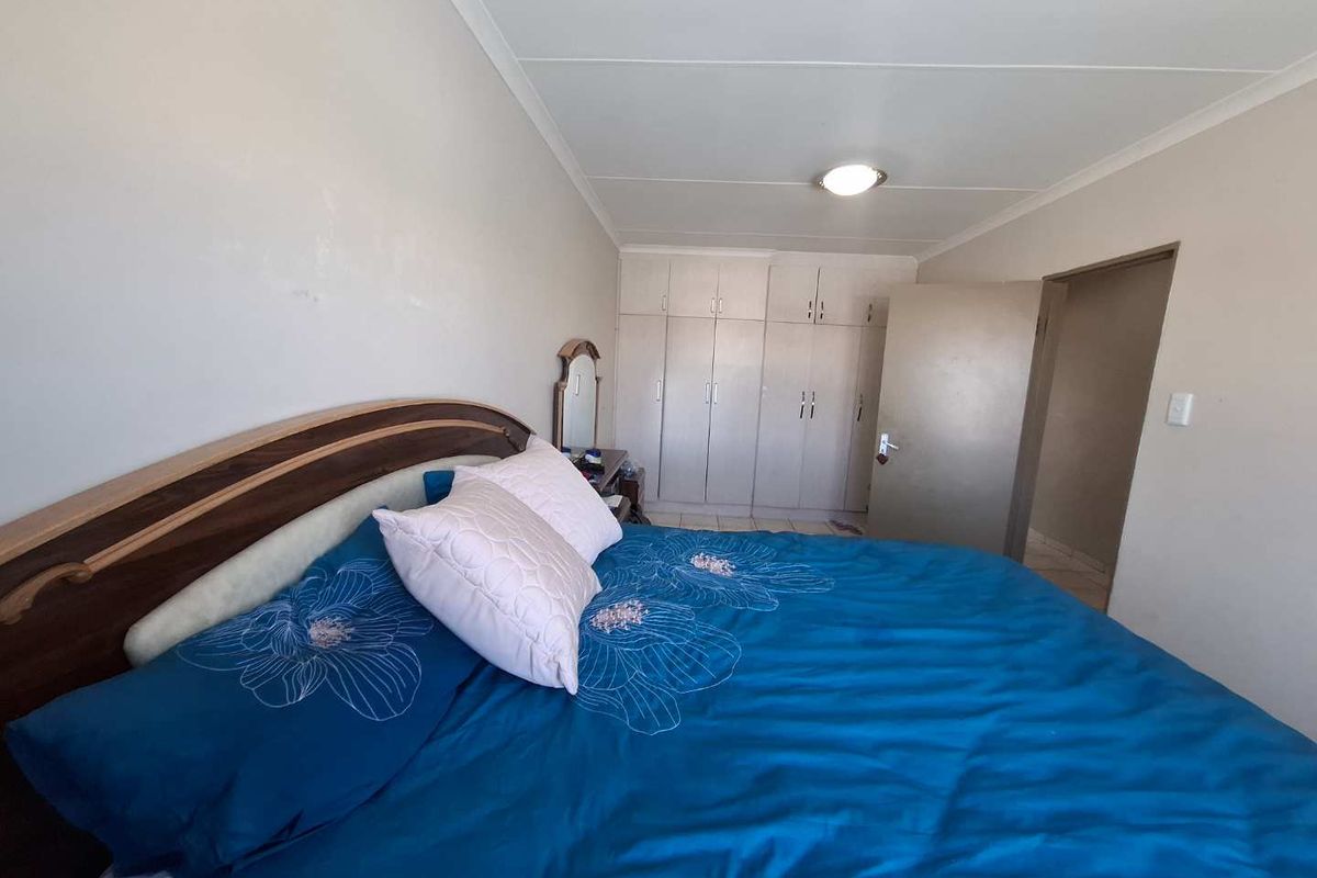 A bedroom featuring built-in cupboards and a standard door, providing functional storage space within the room.