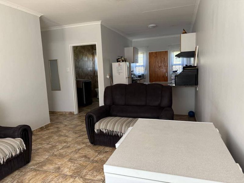 Open plan living and kitchen area featuring tiled flooring and neutral wall finishes, providing a functional layout for daily living.