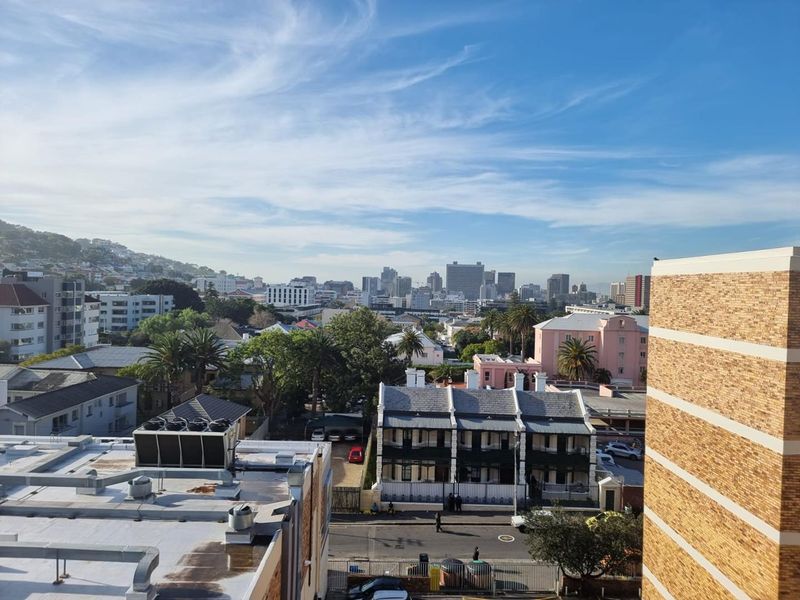 An elevated urban view overlooking the surrounding neighborhood, city skyline, and distant hills from the apartment.