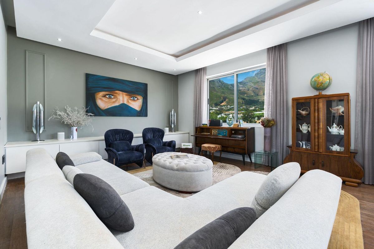 A well-appointed living room featuring recessed ceiling lighting, custom built-in cabinetry, and large windows offering scenic mountain views.