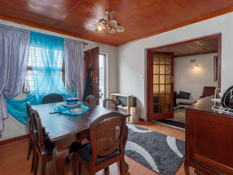 Dining room featuring laminate flooring and a wooden ceiling, with french doors leading to an adjacent living space.