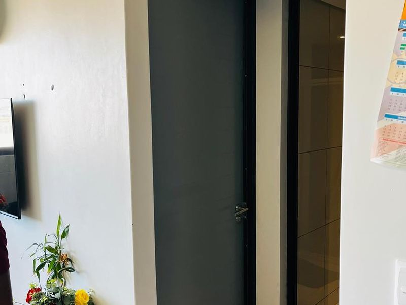 A clean hallway area featuring tiled flooring and modern internal doors with dark frames.