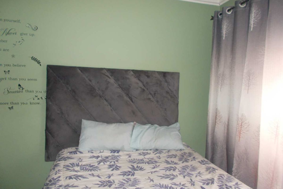 A bedroom featuring green painted walls and decorative crown molding.