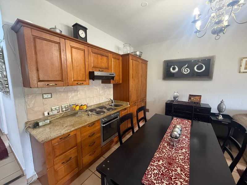 Open plan kitchen and dining area featuring traditional wooden cabinetry, granite countertops, and integrated cooking appliances.