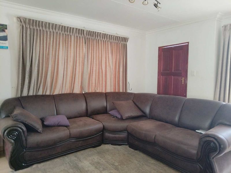 A living room featuring neutral walls, cove cornicing, and a timber door, providing a functional space for relaxation.