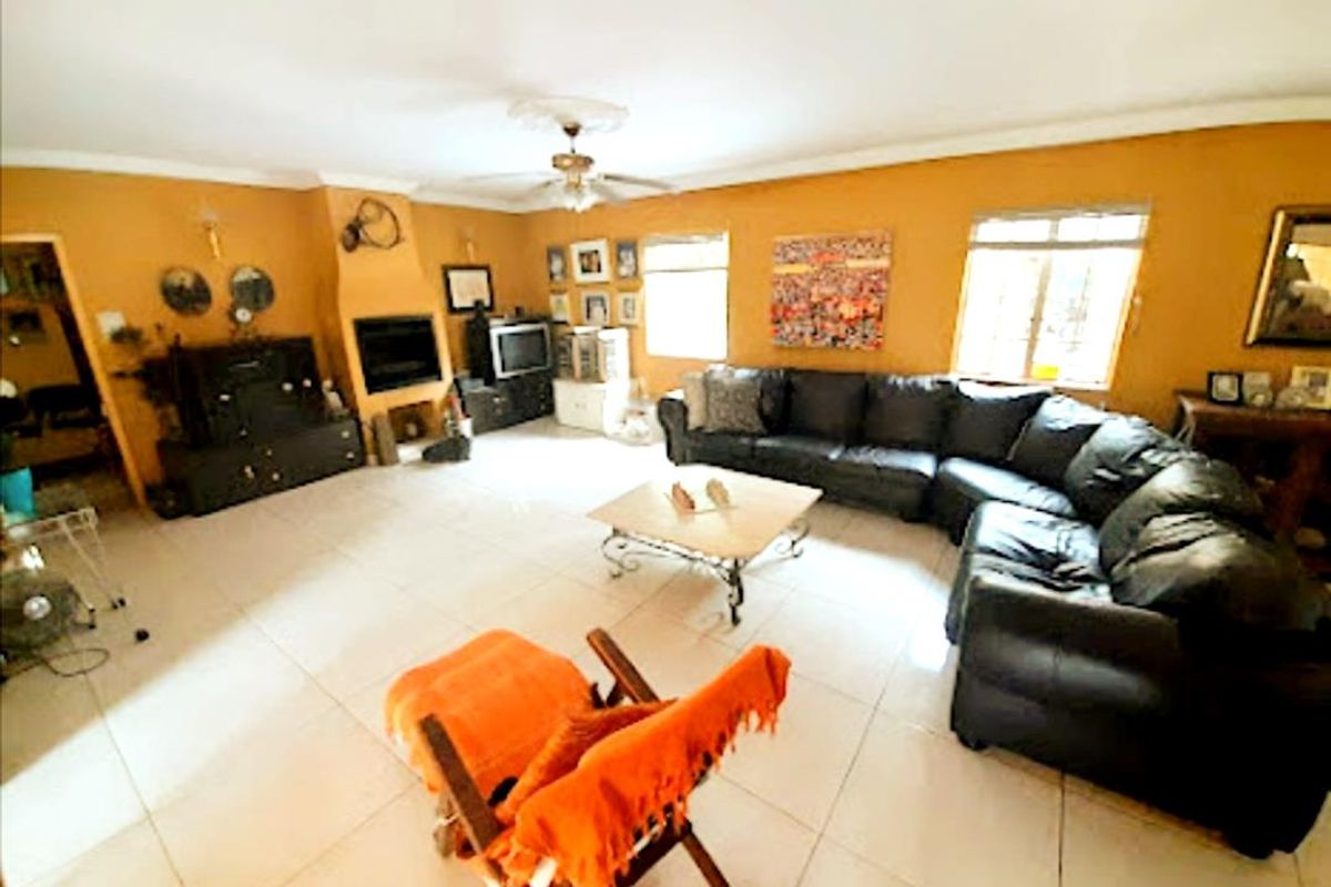 Spacious living room featuring tiled flooring, a built-in fireplace, and large windows providing natural light.