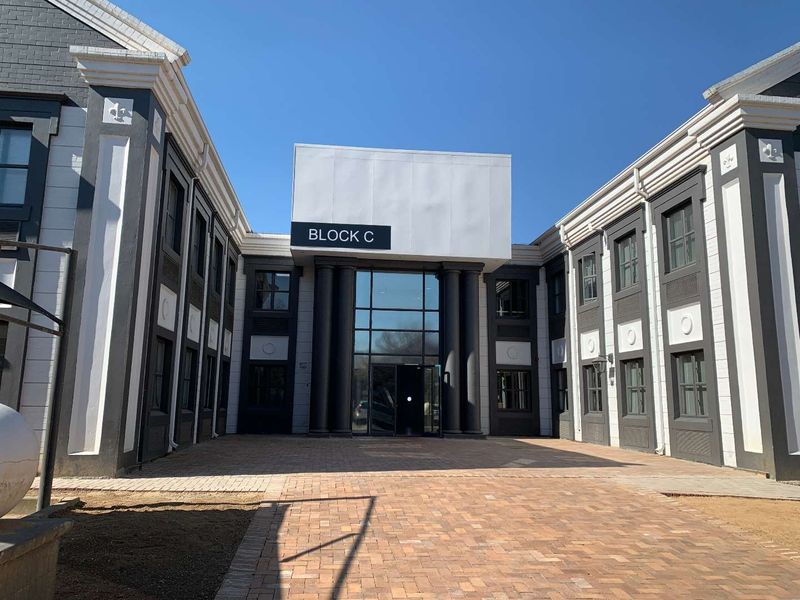 Front exterior view of Block C office building featuring a paved courtyard entrance and modern architectural facade.