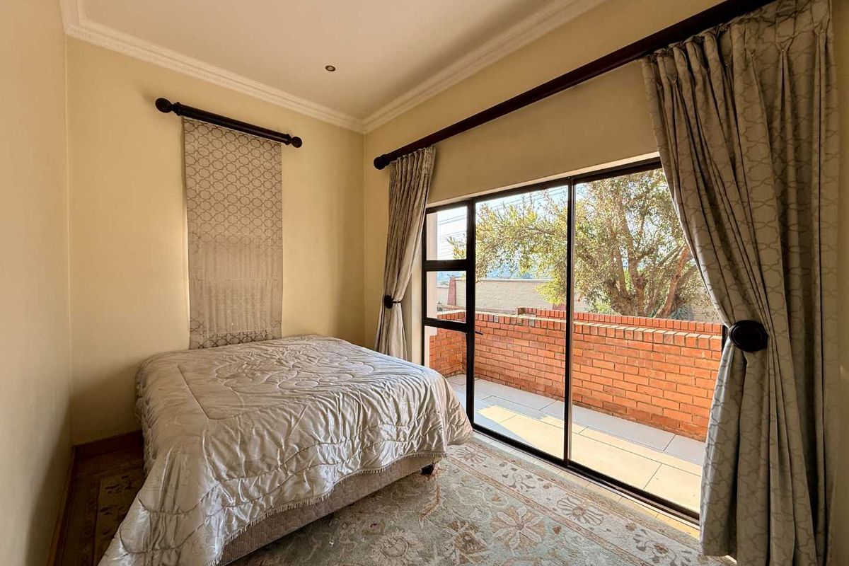 A bedroom featuring a sliding glass door that opens onto a private balcony, providing natural light and outdoor access.