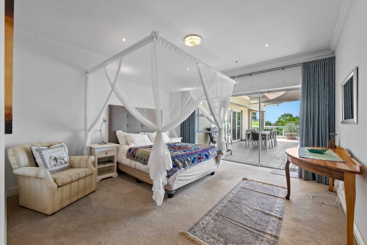 Spacious bedroom featuring neutral carpeting, recessed lighting, and large sliding glass doors providing direct access to an outdoor patio area.