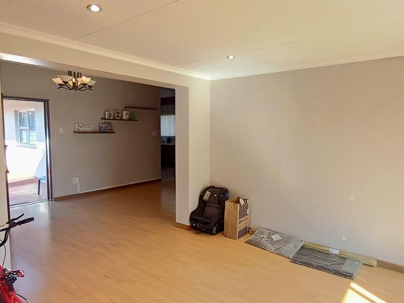 Spacious living area featuring laminate flooring and recessed downlighting, offering a neutral canvas for interior design.