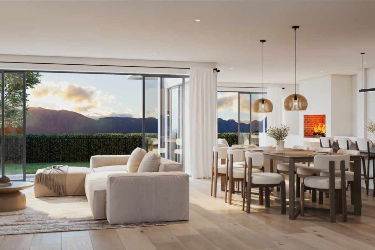 A modern open-plan living, dining, and kitchen area featuring high-end finishes, large sliding doors with mountain views, and a sleek, contemporary design.