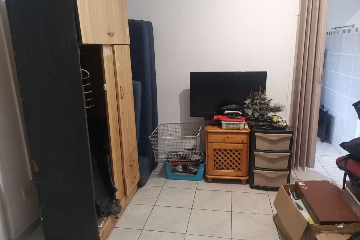 A functional interior space featuring tiled flooring and a neutral wall finish, suitable for use as a bedroom or utility area.