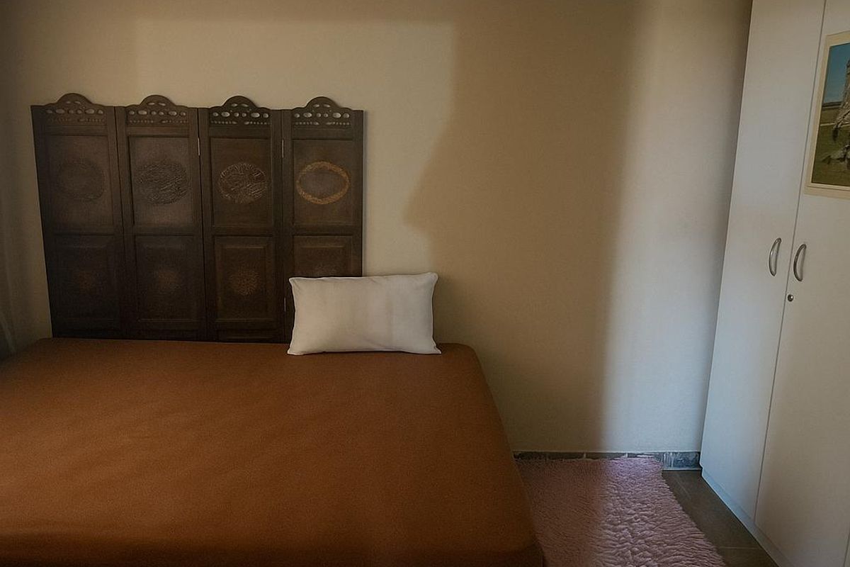 A bedroom featuring a built-in wardrobe and a drop ceiling, providing functional storage and standard finishes.
