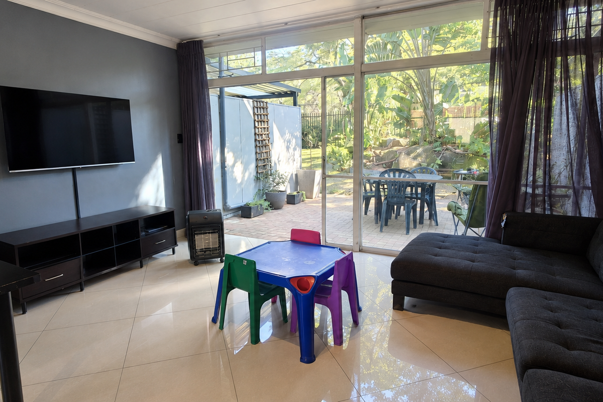 Spacious living room featuring large sliding glass doors that provide natural light and direct access to the outdoor patio area.