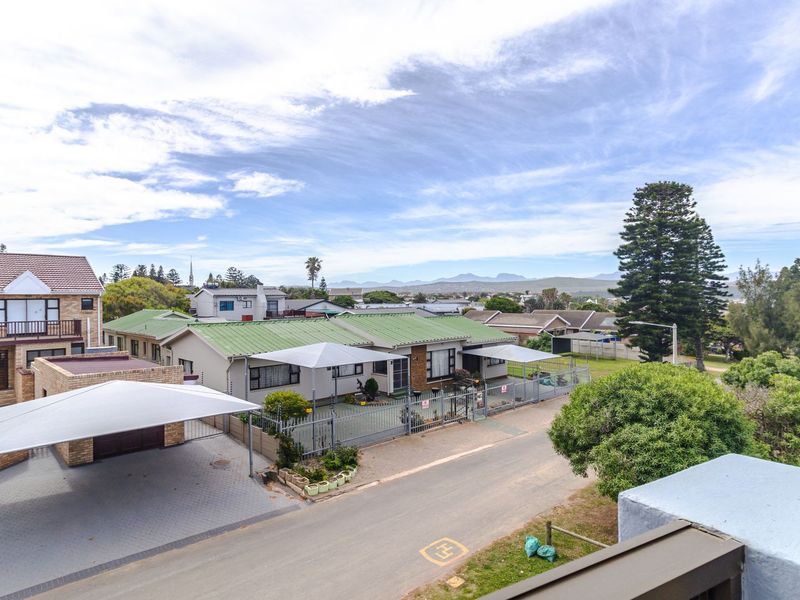 An elevated aerial view of the apartment complex, featuring paved driveways, shade cloth carports, and surrounding residential neighborhood landscape.