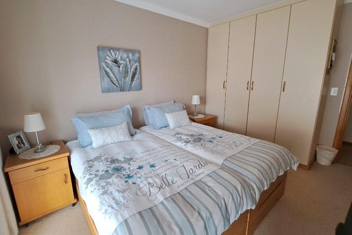 A bedroom featuring built-in floor-to-ceiling wardrobes and neutral wall finishes.