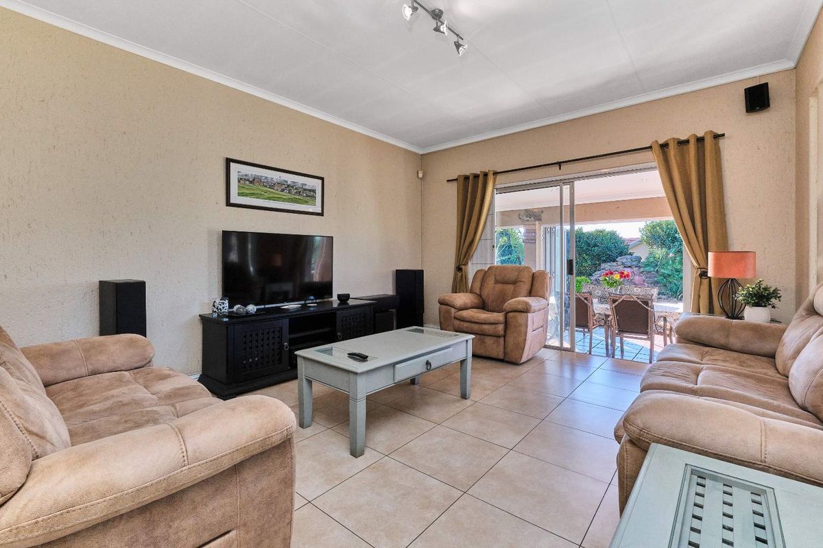 Spacious living room featuring neutral tiled flooring and large sliding glass doors that provide seamless access to the outdoor patio area.