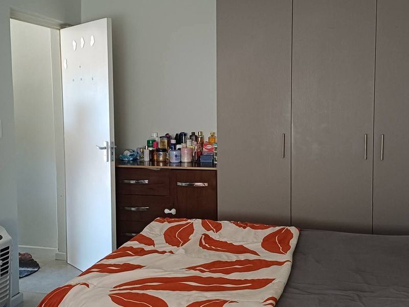 A functional bedroom featuring built-in cupboards and neutral wall finishes, providing a practical space for rest and storage.
