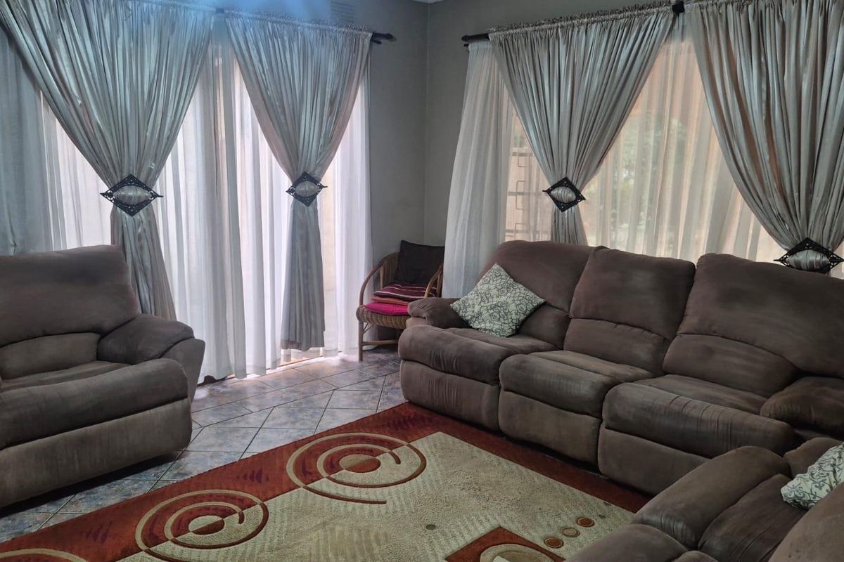 A comfortable living room featuring tiled flooring and large sliding glass doors that provide ample natural light.