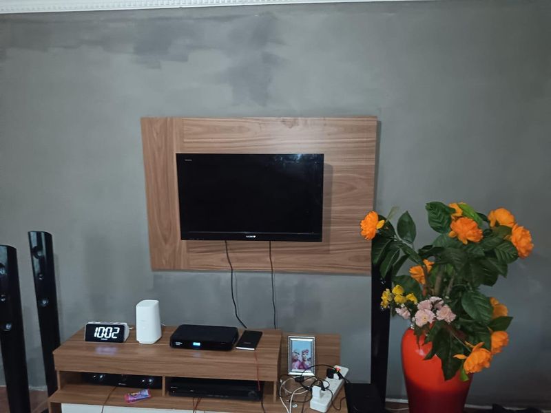 Living room area featuring a wall-mounted television panel and decorative coving, requiring cosmetic wall finishing to improve the overall aesthetic.