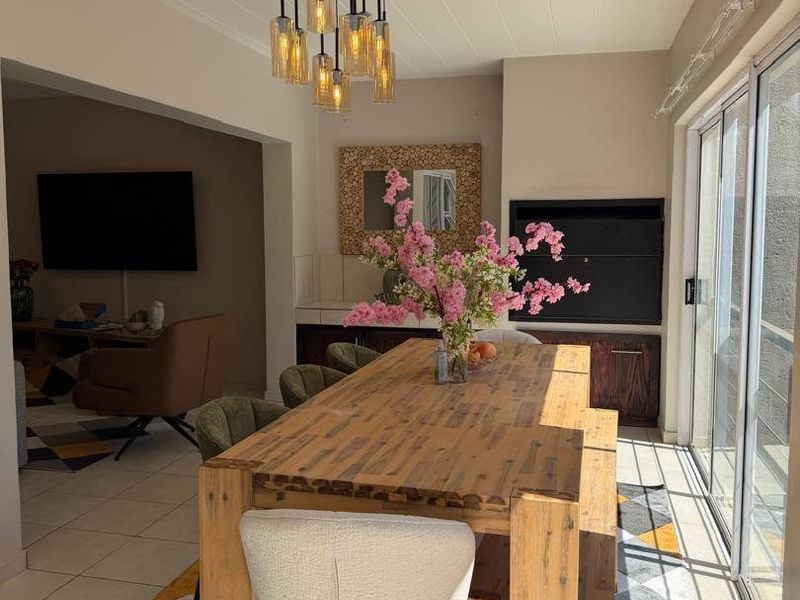 A bright dining area featuring tiled floors, built-in cabinetry, a fireplace, and large sliding glass doors that provide ample natural light.