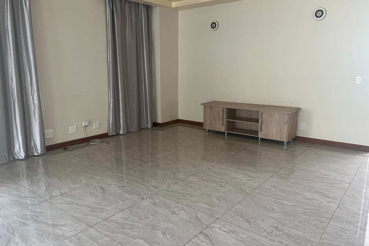 Spacious living area featuring large format polished porcelain floor tiles, recessed ceiling detailing, and neutral wall finishes.