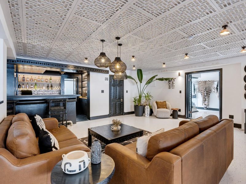Sophisticated bar area featuring a built-in service counter, intricate decorative ceiling panels, and polished terrazzo flooring, creating a high-end entertainment space.