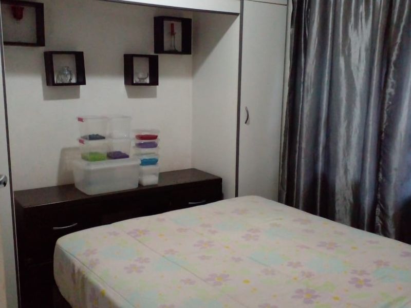 A bedroom featuring white built-in cupboards and a matching built-in vanity unit, providing ample storage space.