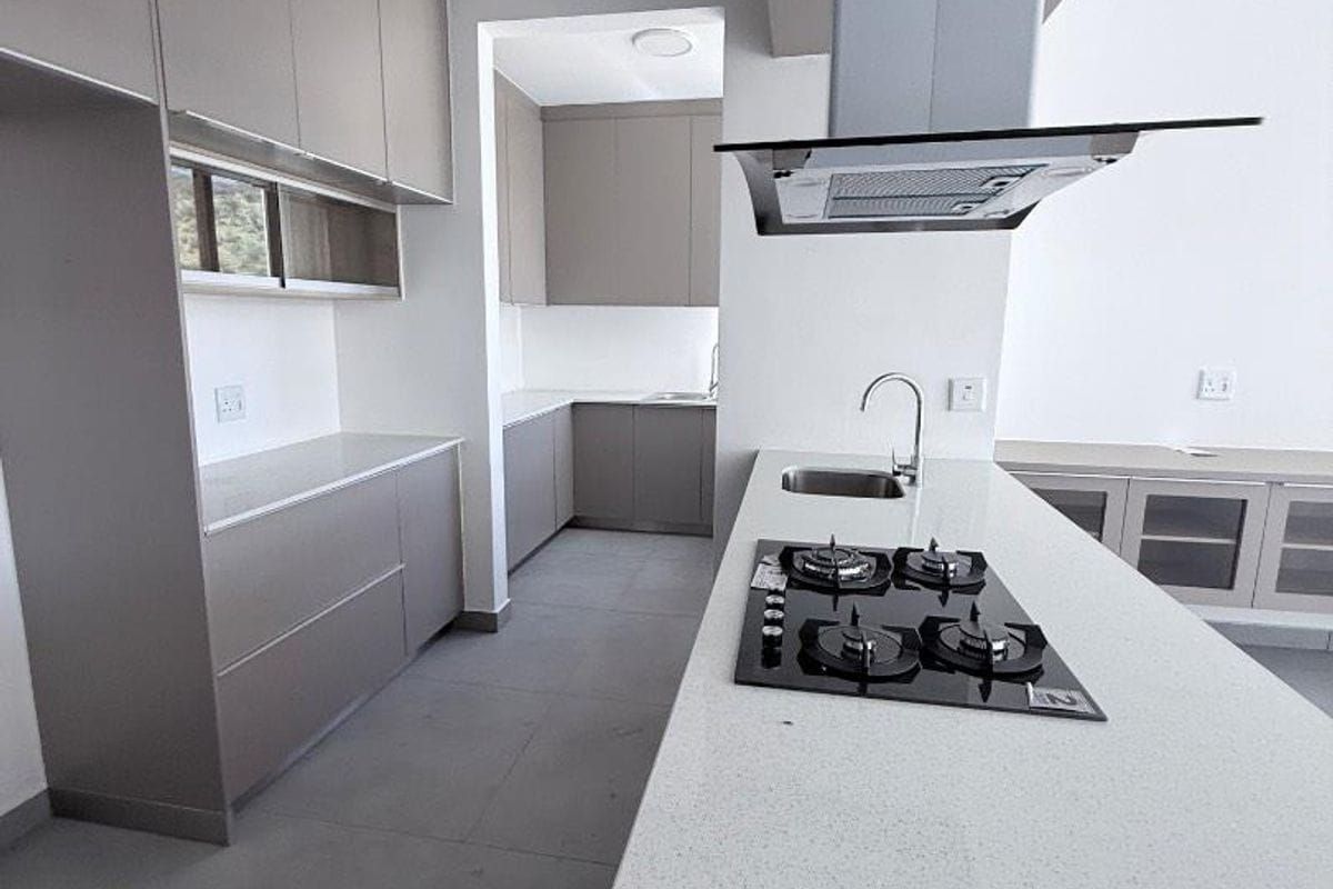 Modern kitchen featuring sleek grey cabinetry, stone countertops, a central island with a gas hob, and an integrated extractor fan.