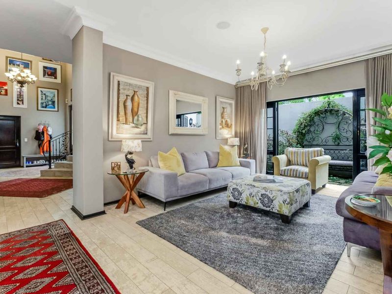 Spacious living room featuring tiled flooring, crown molding, and large sliding glass doors that provide seamless access to the outdoor area.