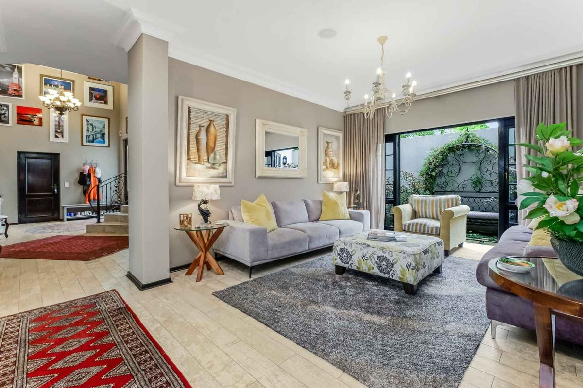 Spacious living room featuring tiled flooring, crown molding, and large sliding glass doors that provide seamless access to the outdoor area.
