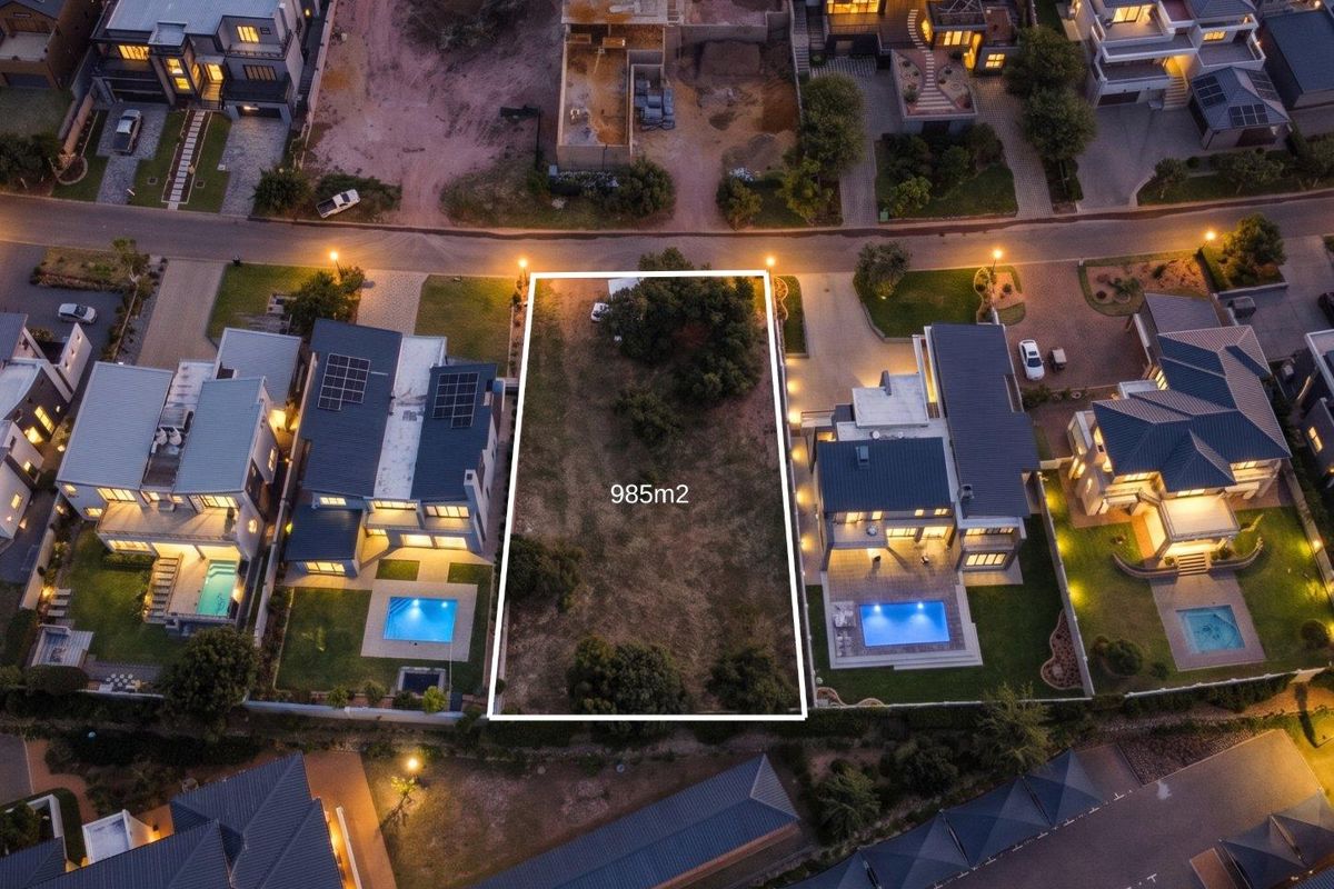 Aerial view of a 985m2 vacant residential plot situated within an established estate, surrounded by modern homes.