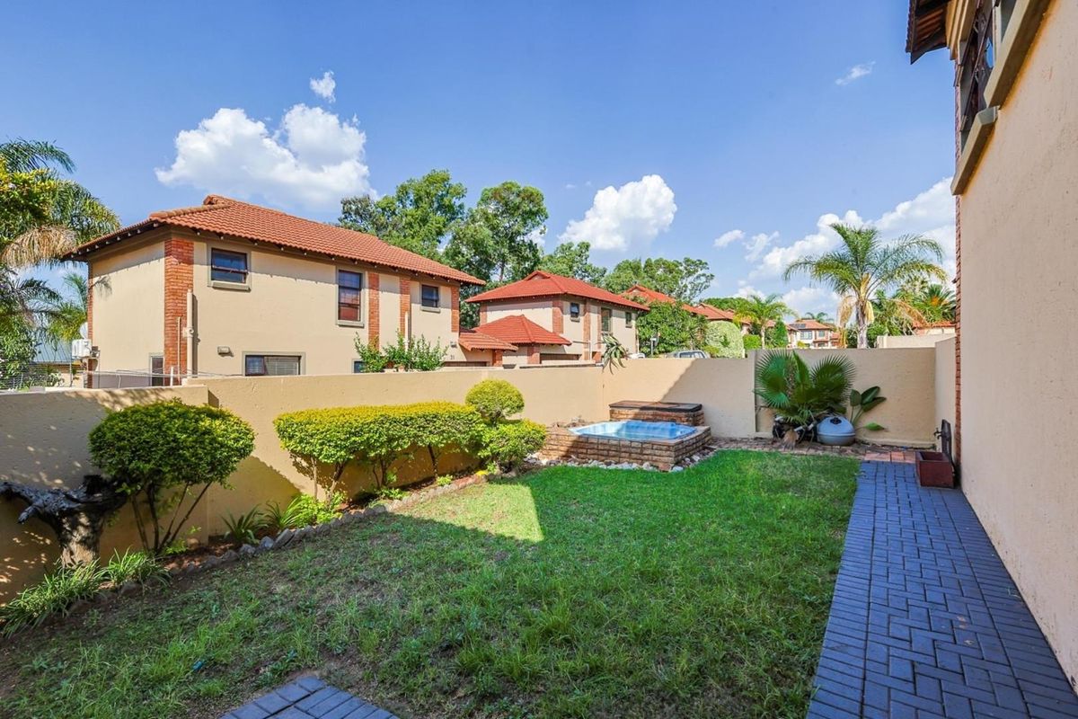 A private rear garden featuring a small plunge pool, paved walkway, and perimeter boundary walls in a residential estate setting.