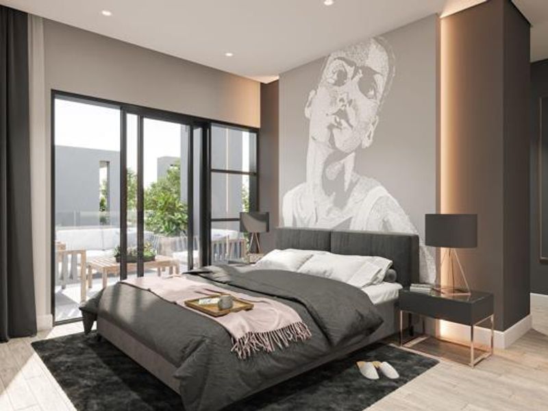 Modern bedroom featuring an accent wall with artistic mural, recessed lighting, and large sliding glass doors providing access to an outdoor patio area.
