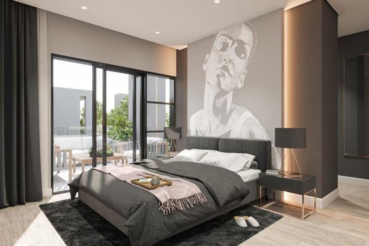 Modern bedroom featuring an accent wall with artistic mural, recessed lighting, and large sliding glass doors providing access to an outdoor patio area.