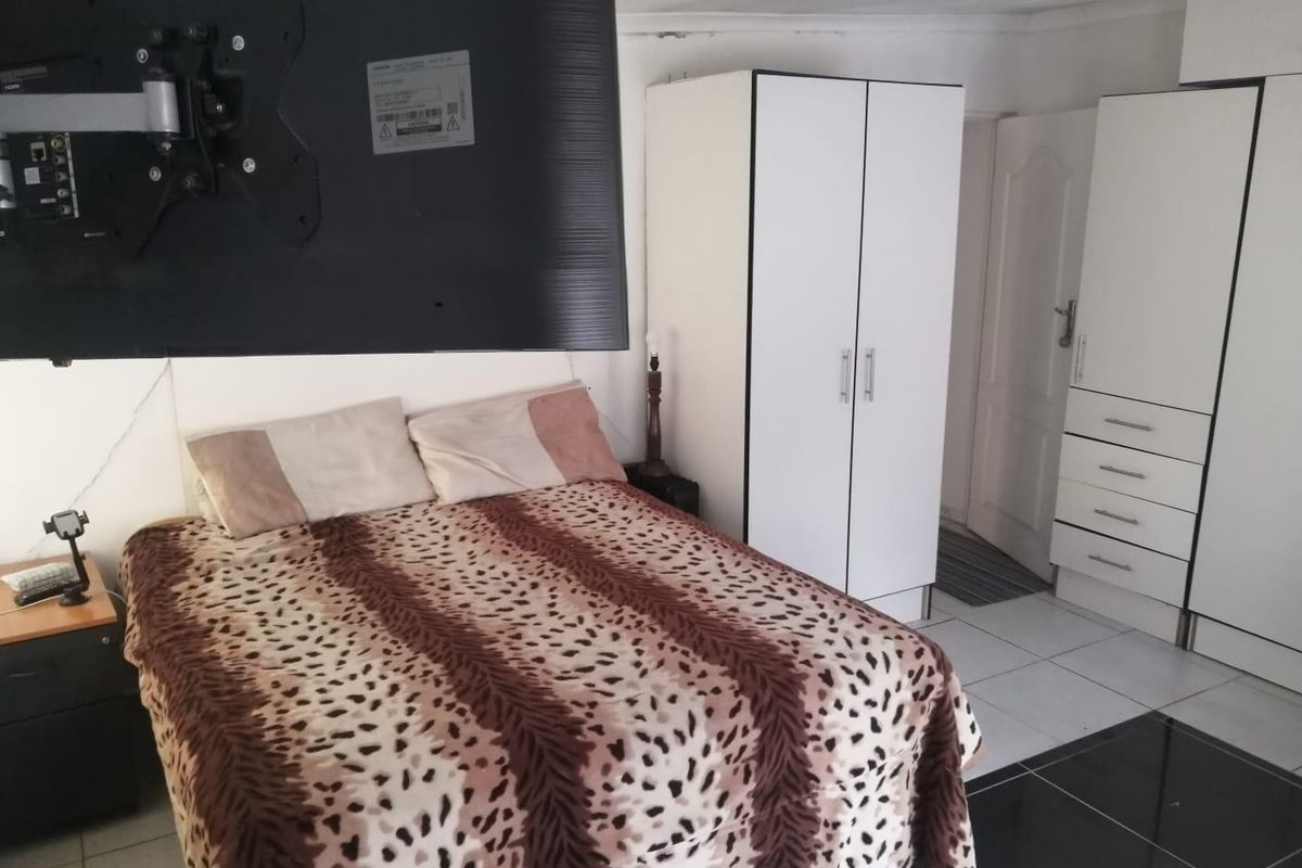 A bedroom featuring built-in cupboards and tiled flooring, providing functional storage and a neutral base for interior updates.