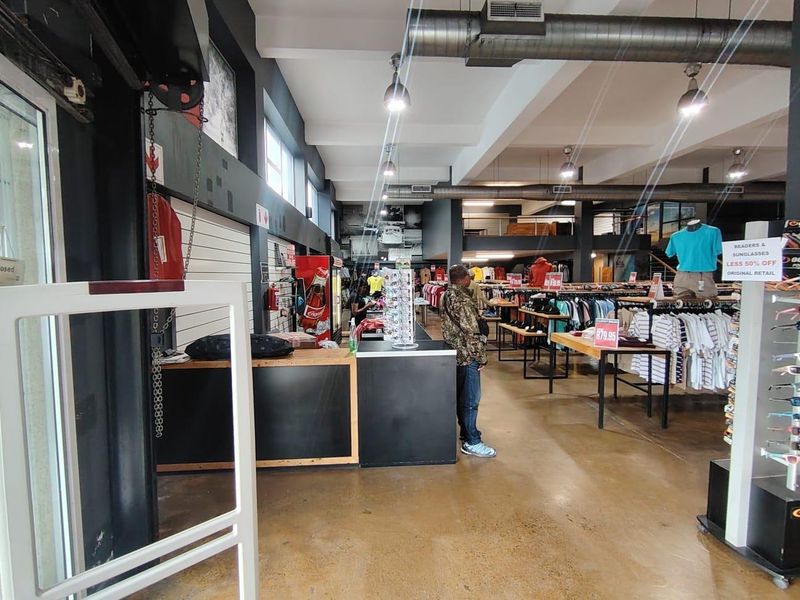 Spacious open-plan retail floor featuring polished concrete flooring, exposed industrial ducting, and a mezzanine level, suitable for various commercial retail applications.