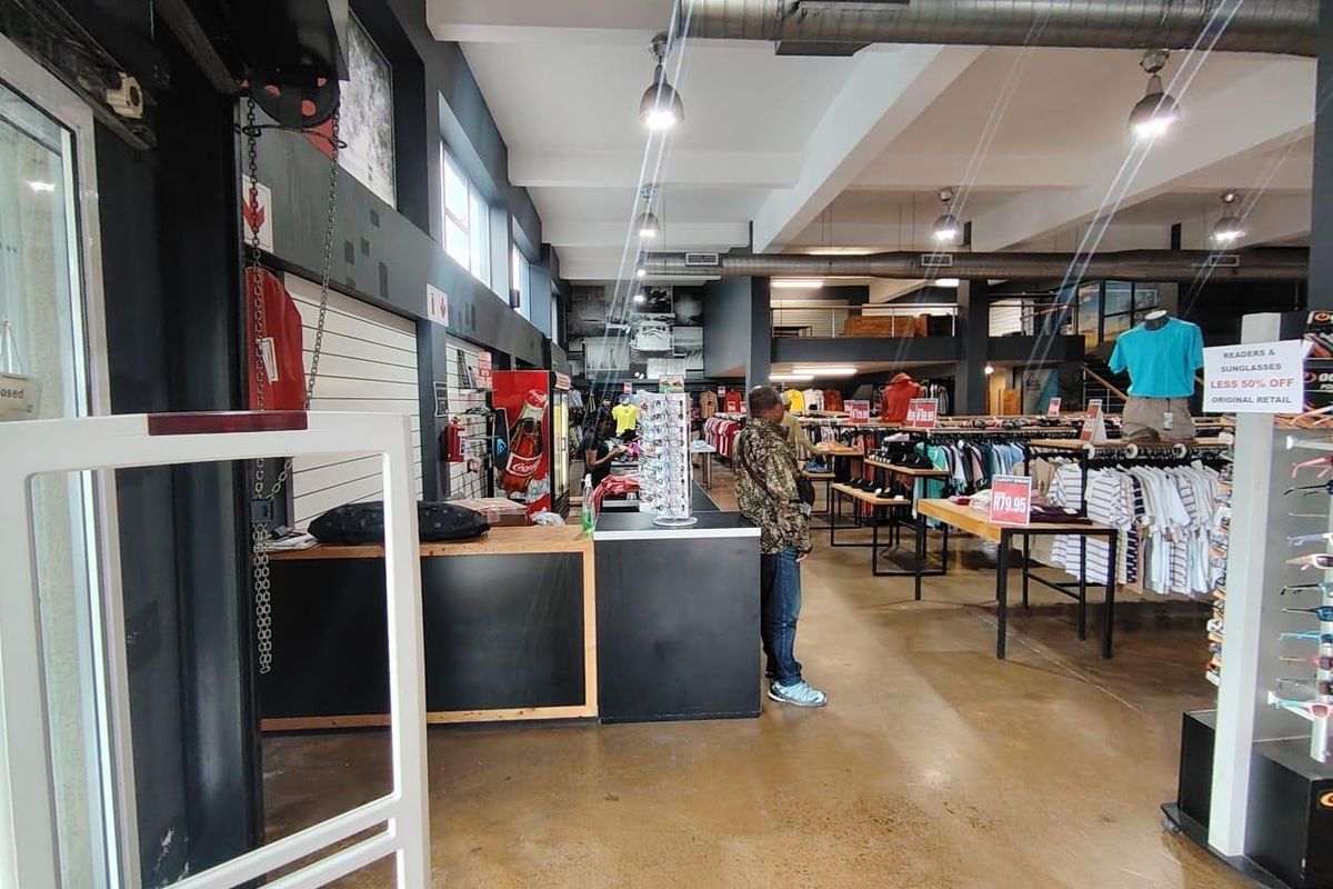 Spacious open-plan retail floor featuring polished concrete flooring, exposed industrial ducting, and a mezzanine level, suitable for various commercial retail applications.