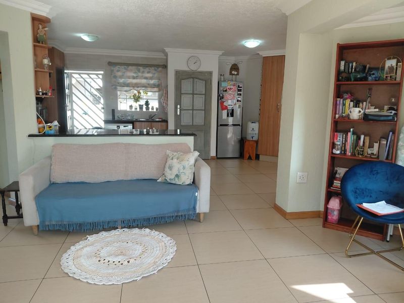 Open-plan living area featuring tiled floors and a functional kitchen with granite countertops, providing a versatile space for daily living and dining.
