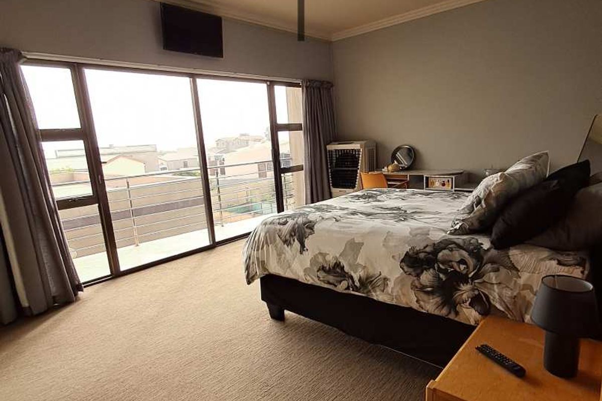 Spacious bedroom featuring large sliding glass doors that open onto a private balcony, providing ample natural light and outdoor access.
