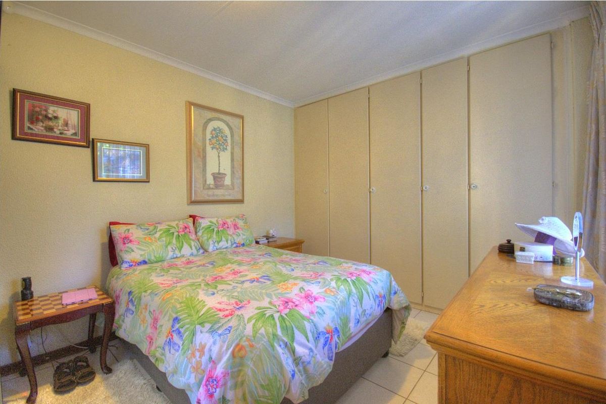 A bedroom featuring built-in floor-to-ceiling cabinetry and tiled flooring, offering functional storage space.